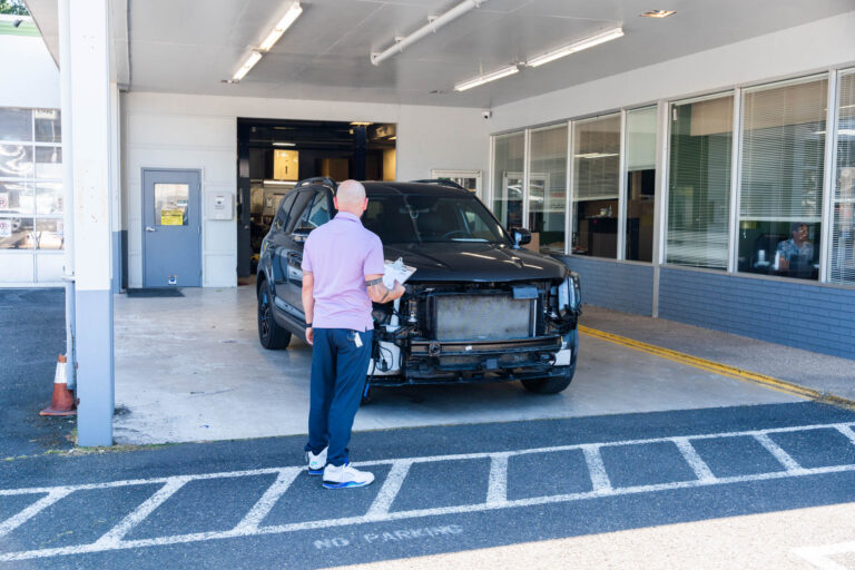 Estimator at Canyon Road Auto Body inspecting damage on kia sorento